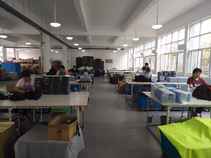 Operators finishing and packing pet products at workshop tables