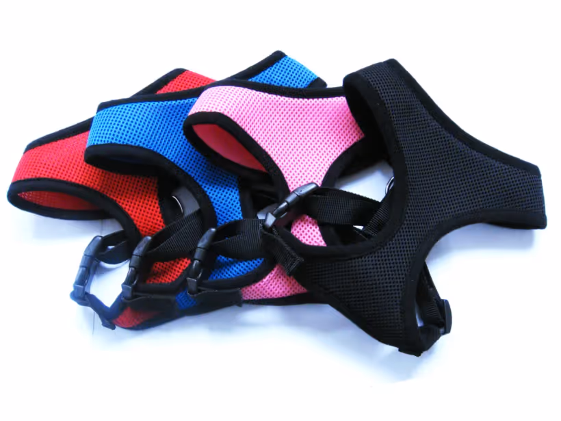 Red, blue, pink and black air-mesh dog harnesses with side-release buckles