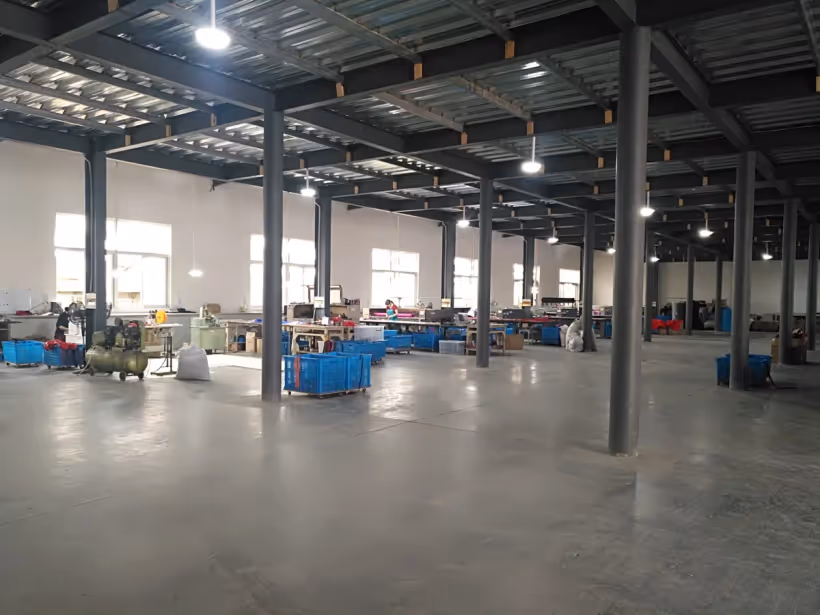 Open production floor with workstations and material bins at the HappyPet Crafts factory